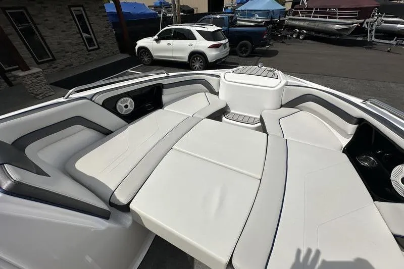Slide: The Image of 2020 Yamaha Boats SX240 interior with spacious seating and modern design in a marina setting. - 40