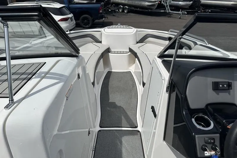 Slide: The Image of 2020 Yamaha Boats SX240 interior with seating and dashboard, parked in a marina. - 43