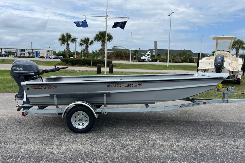 Slide: The Image of 2026 SeaArk DXS 1652 DKLD boat on trailer with Yamaha motor, parked outdoors. - 5