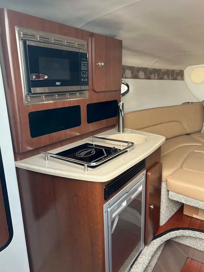 Slide: The Image of Interior of 2023 Crownline 270 CR with kitchenette and seating area. - 11