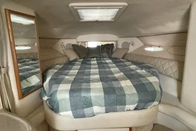 Slide: The Image of Cozy cabin interior of 2000 Sea Ray 290 Sundancer with plaid bedding and mirror. - 12