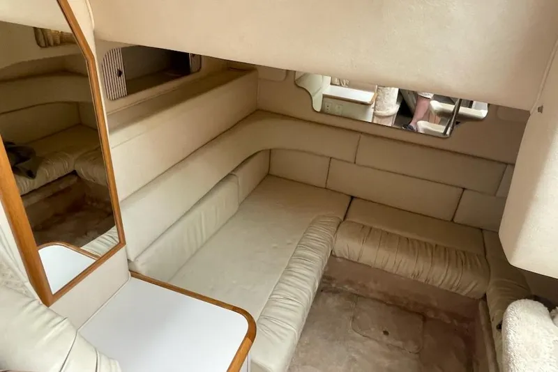 Slide: The Image of Interior of 2000 Sea Ray 290 Sundancer with beige seating and wooden accents. - 7