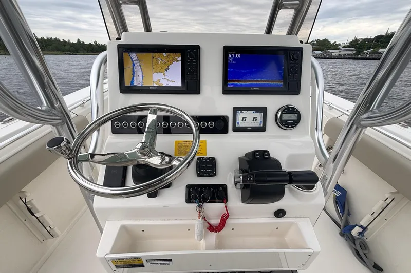 Slide: The Image of 2025 Key West 244 Center Console boat dashboard with navigation screens and steering wheel. - 2