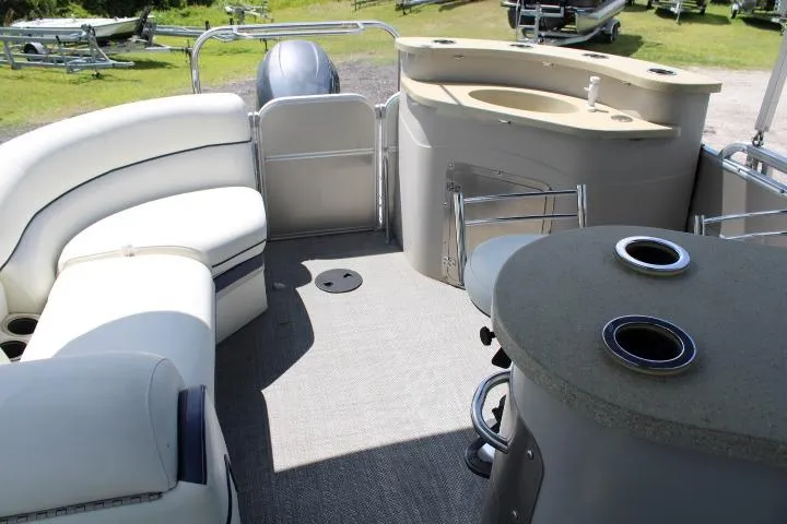 Slide: The Image of 2015 South Bay 524E pontoon boat interior with seating and bar area. - 5