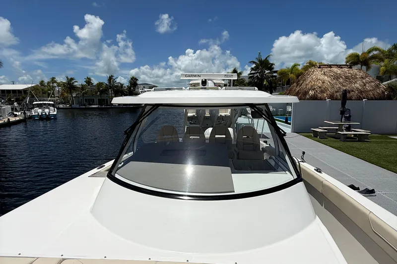 Slide: The Image of 2022 Regal 38 SAV boat docked by waterfront under clear blue sky. - 12