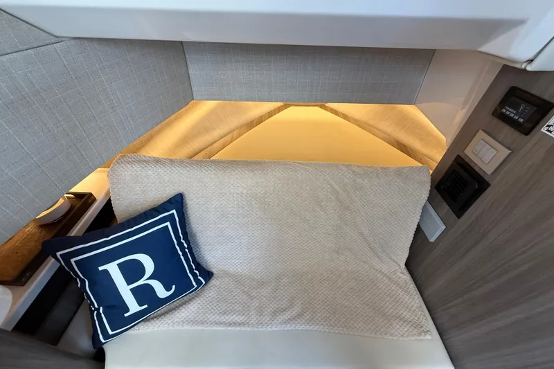 Slide: The Image of 2022 Regal 38 SAV cabin interior with cozy bedding and decorative pillow. - 27