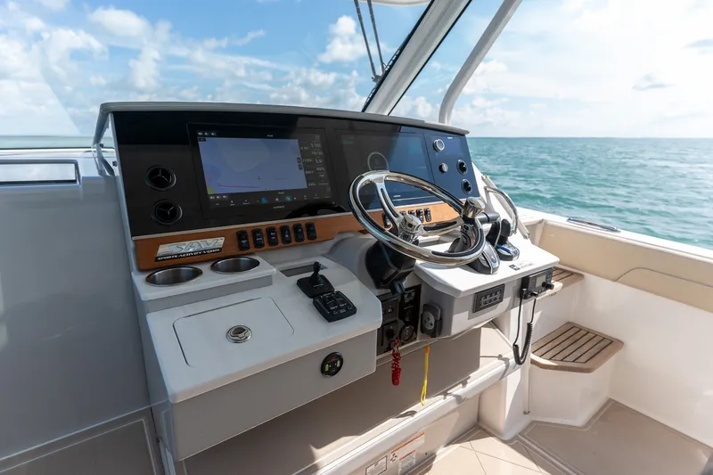 Slide: The Image of Helm of 2022 Regal 38 SAV boat with navigation controls and ocean view. - 42