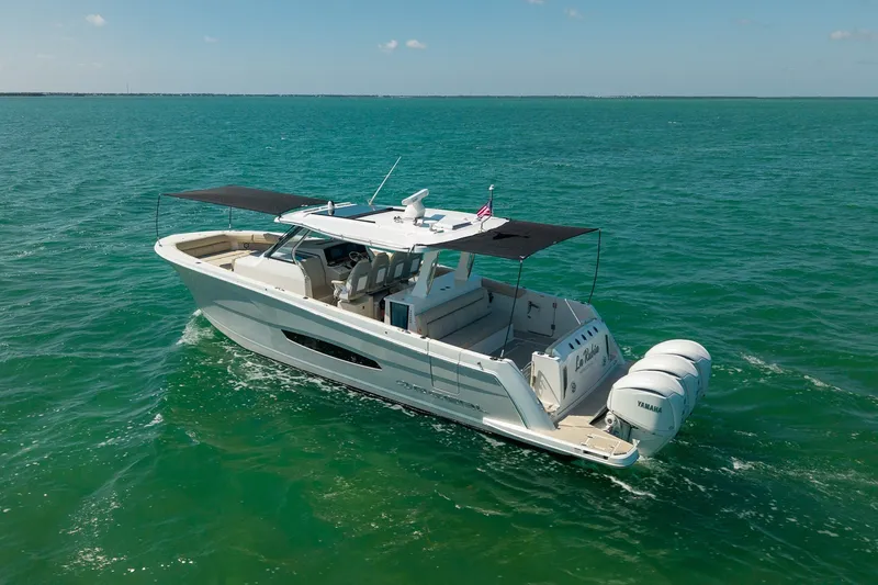 Slide: The Image of 2022 Regal 38 SAV boat cruising on clear blue ocean waters. - 10