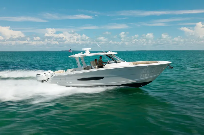 Slide: The Image of 2022 Regal 38 SAV boat cruising on clear blue ocean waters. - 14