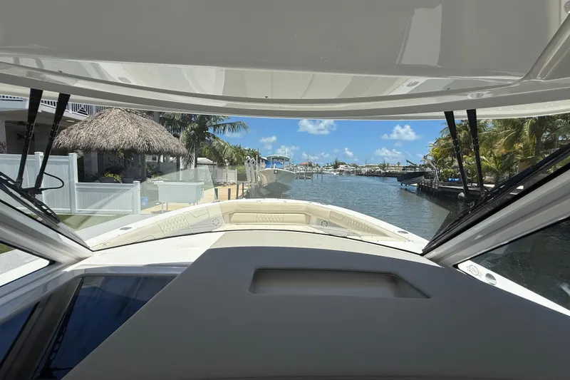 Slide: The Image of View from 2022 Regal 38 SAV boat, overlooking a serene canal with palm trees. - 8