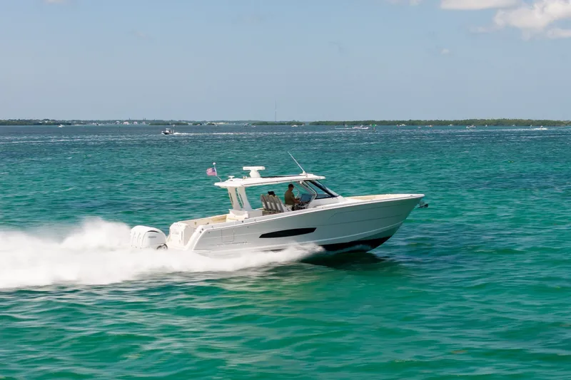 Slide: The Image of 2022 Regal 38 SAV cruising on clear turquoise waters, showcasing sleek design and performance. - 17