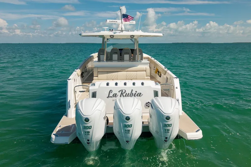 Slide: The Image of 2022 Regal 38 SAV boat with triple engines on clear ocean water. - 6