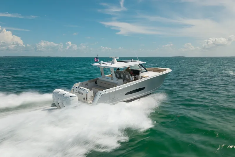 Slide: The Image of 2022 Regal 38 SAV boat cruising on open water under a clear blue sky. - 15