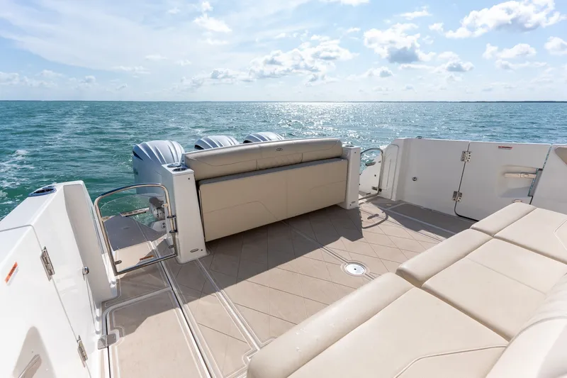 Slide: The Image of 2022 Regal 38 SAV boat deck with luxurious seating, overlooking serene ocean waters. - 21