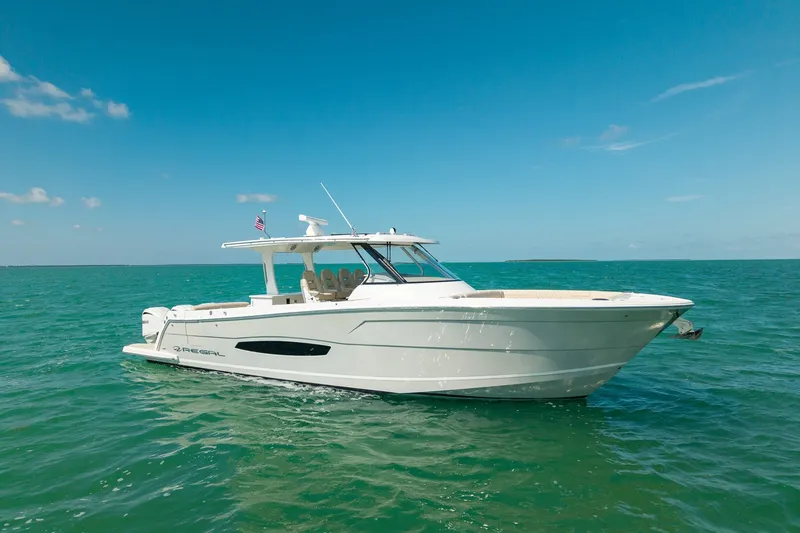 The Image of 2022 Regal 38 SAV boat cruising on clear blue ocean waters. - 0