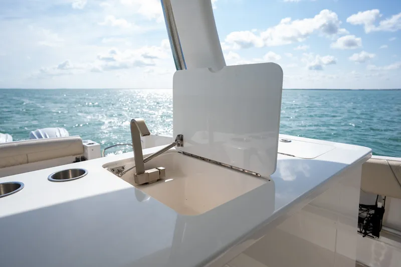 Slide: The Image of 2022 Regal 38 SAV yacht sink with ocean view, showcasing luxury marine design. - 25