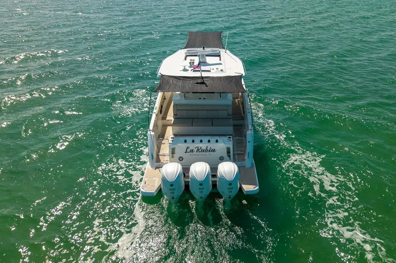 Slide: The Image of 2022 Regal 38 SAV boat cruising on open water with triple outboard engines. - 9