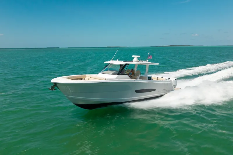 Slide: The Image of 2022 Regal 38 SAV cruising on clear turquoise waters under a bright blue sky. - 19