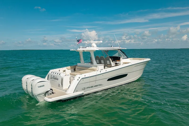 Slide: The Image of 2022 Regal 38 SAV boat on clear blue water, featuring Yamaha engines. - 1