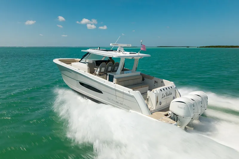 Slide: The Image of 2022 Regal 38 SAV boat cruising on turquoise waters under a clear blue sky. - 18