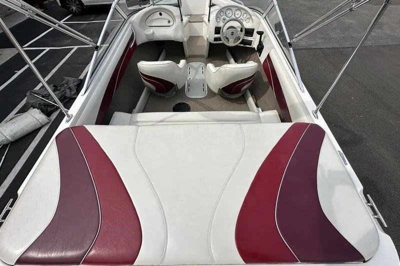 Slide: The Image of Interior of a 2000 Ebbtide Campione 182 boat with red and white seating. - 10