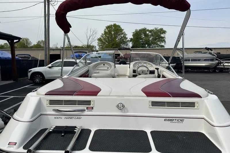 Slide: The Image of 2000 Ebbtide Campione 182 boat with maroon accents, parked in a lot. - 6