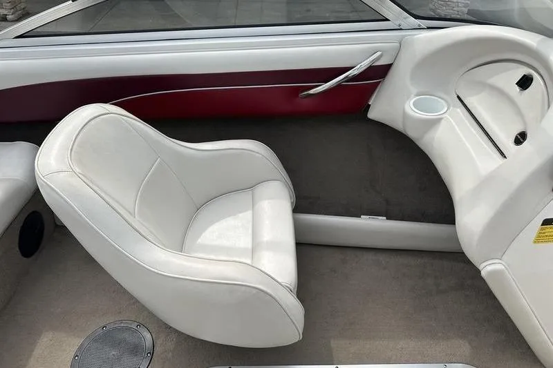 Slide: The Image of Interior of a 2000 Ebbtide Campione 182 boat with white seating and red accents. - 9