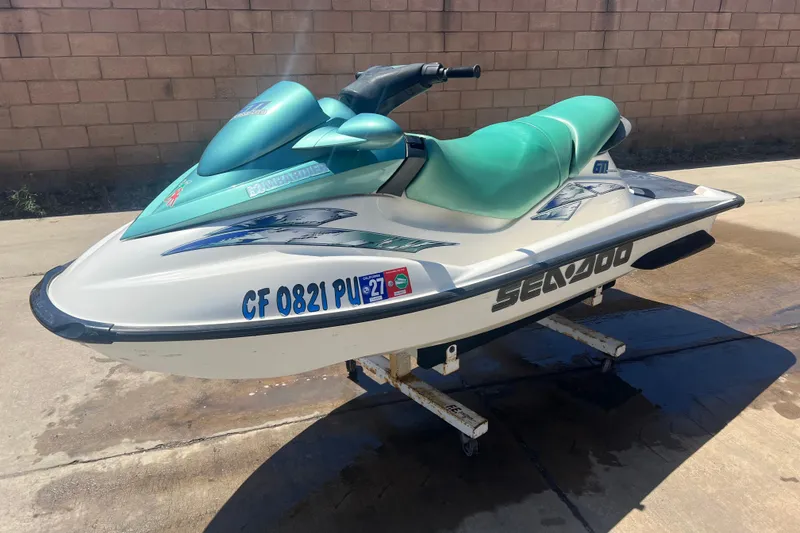 The Image of 2001 Sea-Doo GTI jet ski with green seat, parked on a stand outdoors. - 1