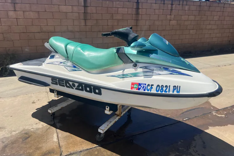 Slide: The Image of 2001 Sea-Doo GTI jet ski with green seat, parked on a stand outdoors. - 5