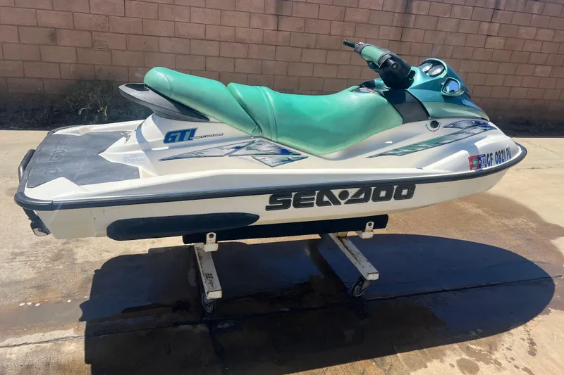 Slide: The Image of 2001 Sea-Doo GTI jet ski with green seat, displayed on a stand outdoors. - 6