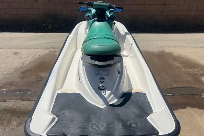 Slide: The Image of 2001 Sea-Doo GTI jet ski with green seat, parked on concrete surface. - 8