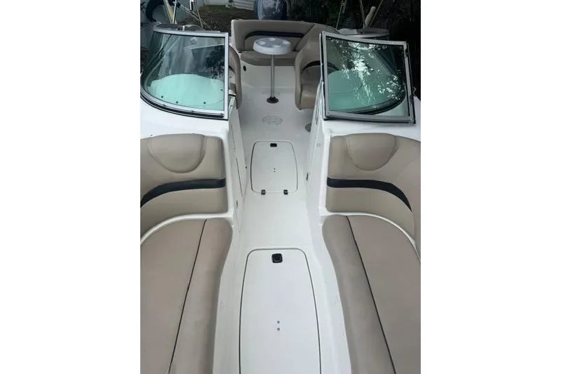 Slide: The Image of 2015 Hurricane SunDeck 2400 OB boat interior with beige seating and table. - 13