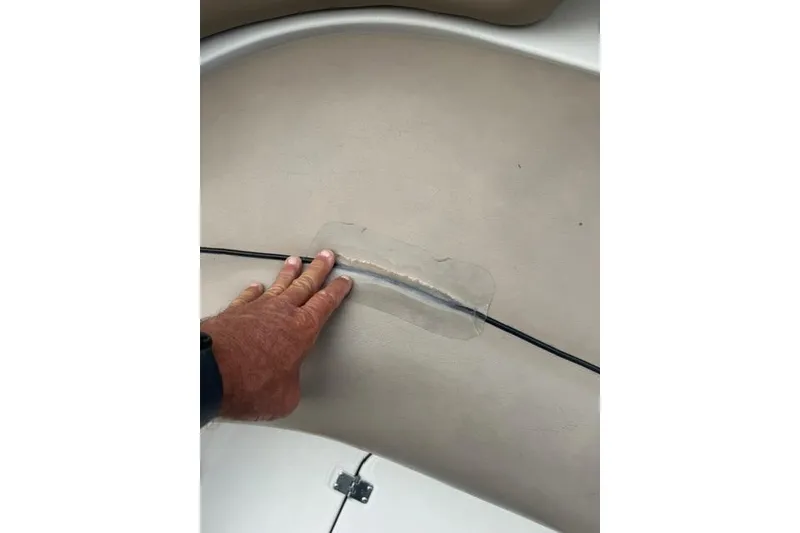 Slide: The Image of Hand inspecting seat seam on 2015 Hurricane SunDeck 2400 OB boat. - 14