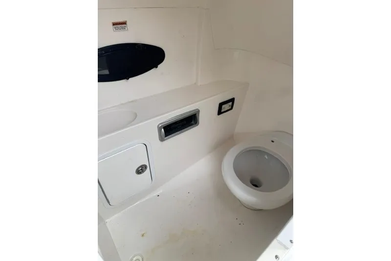 Slide: The Image of Interior of 2015 Hurricane SunDeck 2400 OB boat bathroom with toilet and storage. - 15