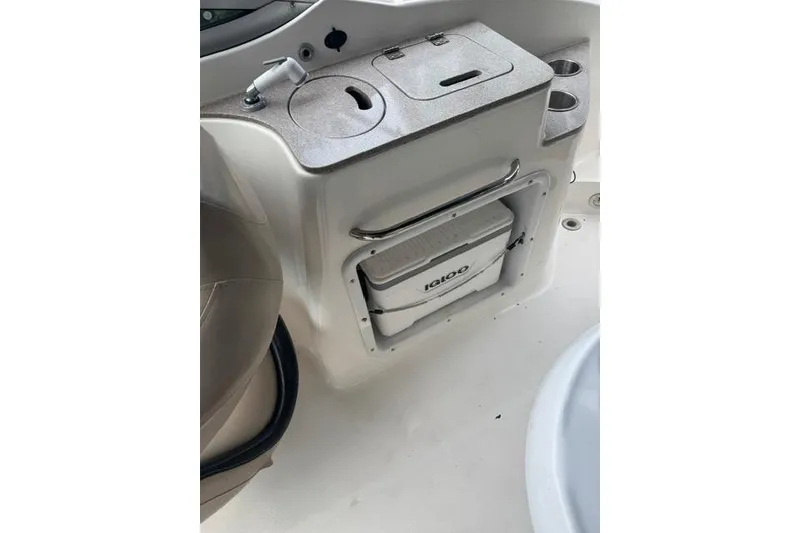 Slide: The Image of 2015 Hurricane SunDeck 2400 OB boat interior with storage compartment and cooler. - 17