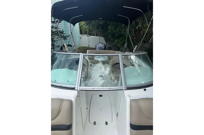 Slide: The Image of 2015 Hurricane SunDeck 2400 OB boat with canopy and seating, docked outdoors. - 21