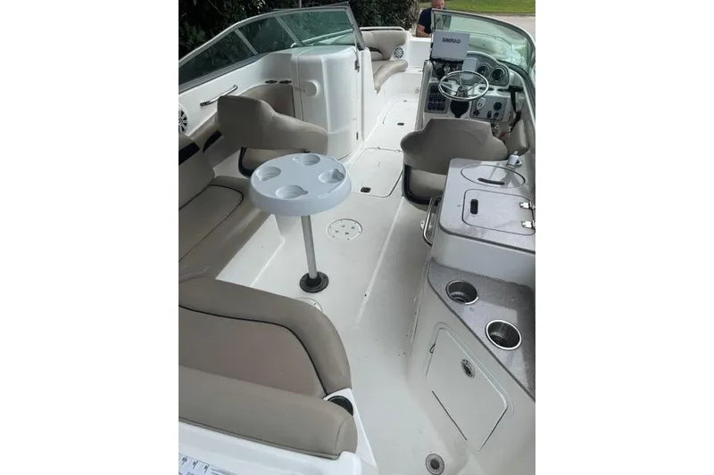 Slide: The Image of 2015 Hurricane SunDeck 2400 OB boat interior with seating, table, and helm. - 25