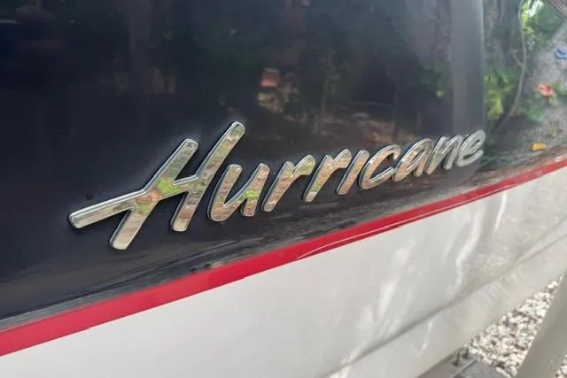 Slide: The Image of 2015 Hurricane SunDeck 2400 OB boat logo with sleek design and red accent stripe. - 26