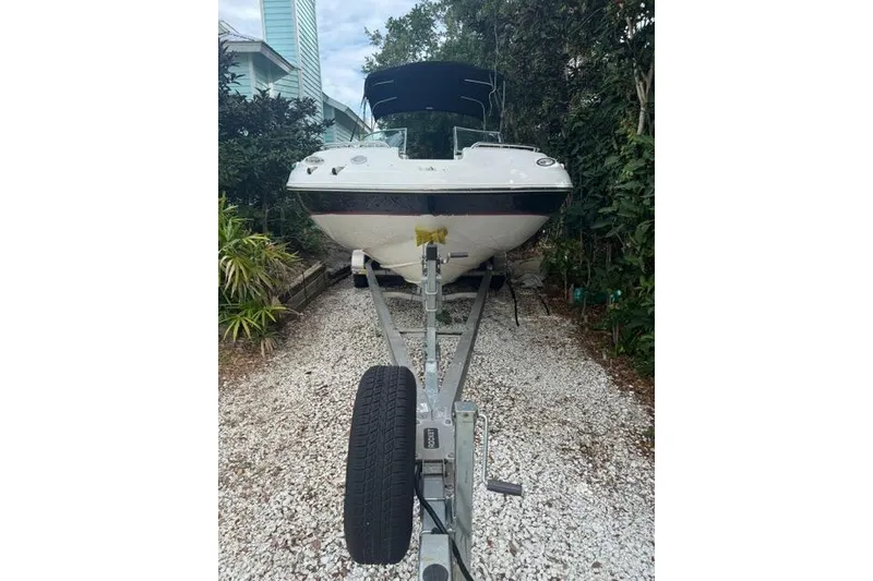 Slide: The Image of 2015 Hurricane SunDeck 2400 OB boat on trailer, parked on gravel driveway. - 3