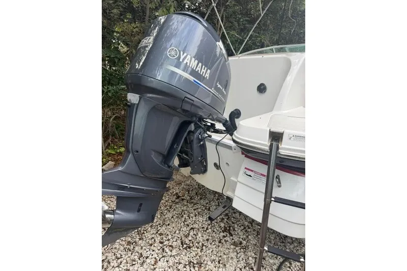 Slide: The Image of 2015 Hurricane SunDeck 2400 OB with Yamaha outboard motor, parked on gravel. - 4