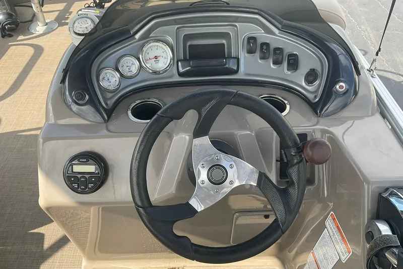Slide: The Image of 2021 Sun Tracker Fishin' Barge 20 DLX dashboard with steering wheel and gauges. - 16