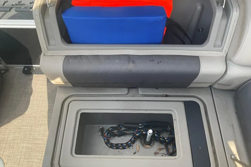 Slide: The Image of Storage compartment on a 2021 Sun Tracker Fishin' Barge 20 DLX with coiled rope inside. - 17