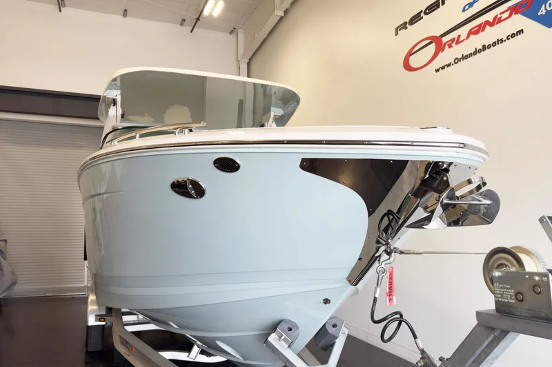 Slide: The Image of 2024 Regal LX9 boat in showroom, displayed on a trailer. - 2