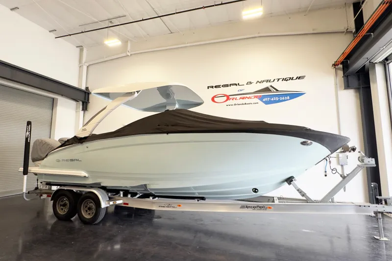 Slide: The Image of 2024 Regal LX9 boat on trailer in showroom, covered and ready for transport. - 3