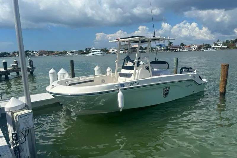 Slide: The Image of 2023 Bayliner Trophy T22CC boat docked in a scenic marina setting. - 1