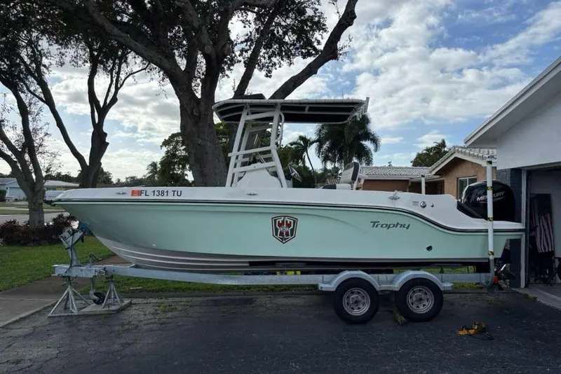 Slide: The Image of 2023 Bayliner Trophy T22CC boat on trailer, parked in residential driveway. - 3