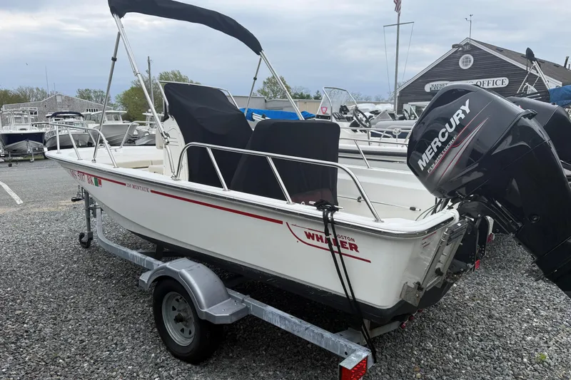 Slide: The Image of 2019 Boston Whaler 150 Montauk boat on trailer with Mercury outboard motor. - 1