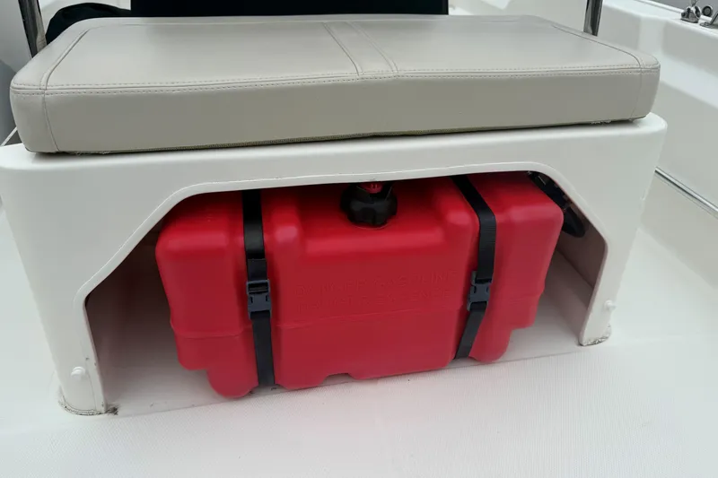 Slide: The Image of 2019 Boston Whaler 150 Montauk boat seat with red fuel tank storage underneath. - 10