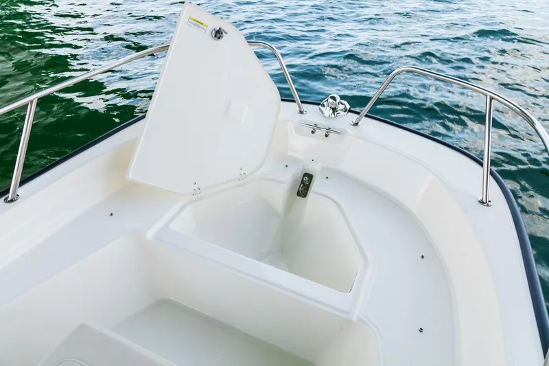 Slide: The Image of Manufacturer Provided Image: 2019 Boston Whaler 150 Montauk boat storage compartment open on water. - 6