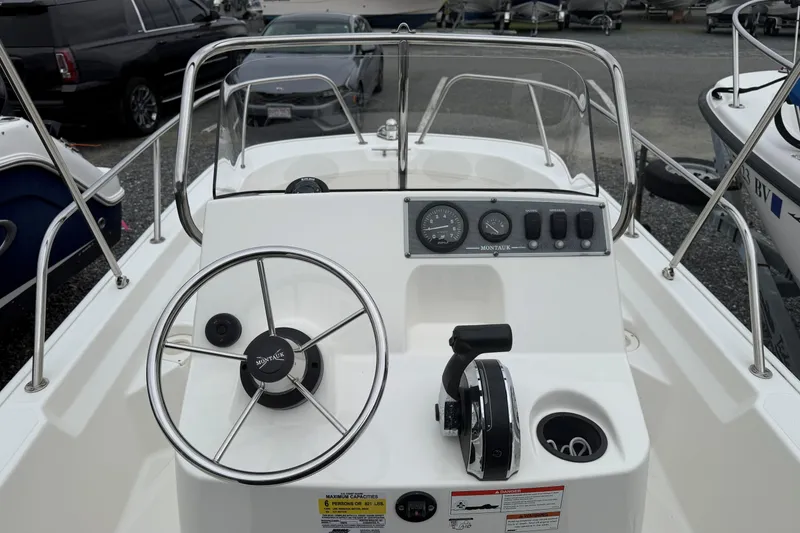 Slide: The Image of 2019 Boston Whaler 150 Montauk boat dashboard with steering wheel and controls. - 8